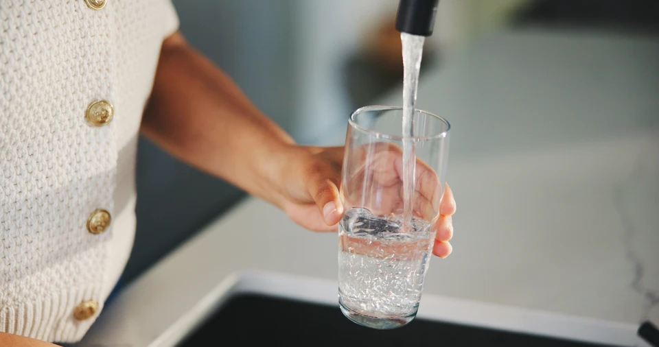 Faucet et goutte d'eau sur fond blanc