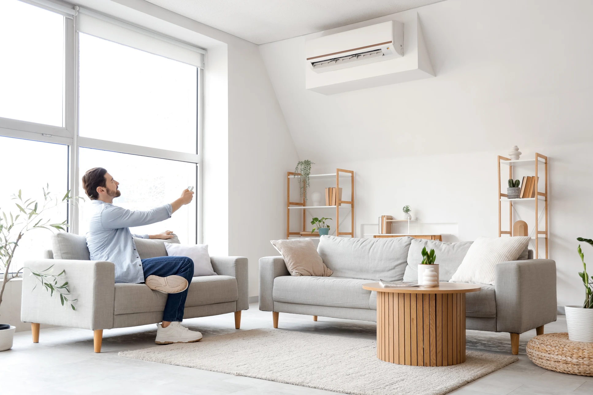 Un technicien en climatisation travaille à l'extérieur sur une unité de climatisation murale